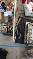 Wide shot of all game items including sticks for crochet, multiple hula hoops, and boxes including cornhole and horseshoe.