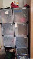 Front view of the cube organizer showing six compartments with closed grey doors featuring swirl patterns and ventilation holes.