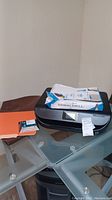 HP Envy 5055 printer on glass table with paper on top, showing printer's front and touch screen panel.