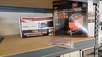 Both boxed power tools on shelf, showing brand names and model information for both.