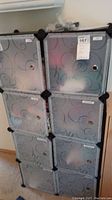 Front view of black modular plastic storage unit with six compartments and swirl-patterned frosted doors.