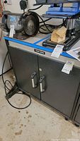 Front view of Black & Decker metal cabinet with two doors showing handles and brand plate.