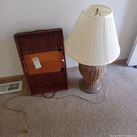 Photo showing both the wicker tray and the table lamp together on carpeted floor, tray resting sideways showing wooden bottom.