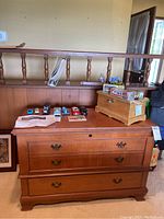 Front view of Cavalier cedar hope chest showing three drawers with brass handles and some items on top.