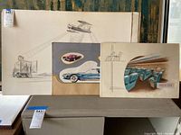 Three industrial design drawings displayed side by side on a table, showing varied design subjects including a vehicle, automobile, and seating plan.