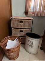 Full view of the wicker chest with three drawers and the two waste baskets in front, showing the different basket styles.