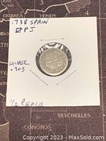 Front side of the 1738 Spain silver 1/2 real coin enclosed in holder with handwritten notes showing date, origin, silver content, and denomination.