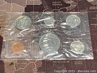 Photo of 6 Canadian coins sealed in original plastic packaging, arranged in two rows: penny, quarter, half dollar on top; nickel, dollar, dime on bottom.
