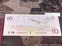 Reverse side of 1989 Canadian $10 banknote featuring a bird in flight and the serial number BDD0566897.