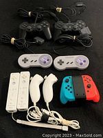 Full lot of controllers laid out on black surface