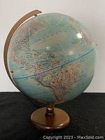 Full view of the 12-inch diameter globe on a wooden stand showing continents and countries in pastel colors with blue oceans.