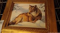 Front view of framed wolf in snow wall art on wire shelf