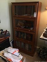 Full front view of the four-section bookcase showing glass doors and wooden framework in a home setting.