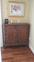 Front view of cabinet showing distressed multi-tone finish and double doors