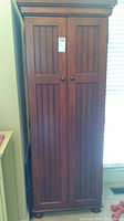 Full front view of cabinet showing two paneled doors and bun feet