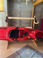 Front view of Talic kayak stand holding a red kayak