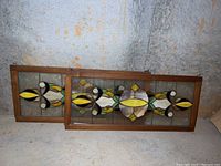 Two stained glass panels side by side leaning against wall