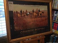 Framed Cowboy Poetry exhibition poster showing seven cowboys on horseback in a western landscape, in an ornate gold-tone frame.