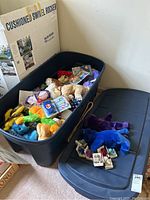 Large plastic bin filled with assorted mini Beanie Babies including animals, bears, dogs, some in original packaging.