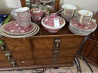 Full view of the dish set including plates, bowls, teapot, and cups arranged on a wooden dresser.