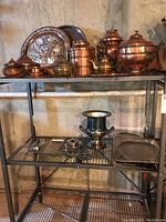 Full shelving unit view displaying all copper servingware pieces