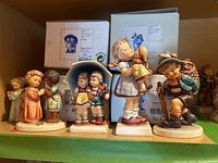 Shelf view showing five figurines and boxes behind them