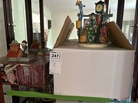 Wide shot of both figurines with their original boxes in a display case