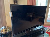 Front view of Samsung 55 inch TV with black frame and stand.