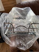 Front view of one metal basket shelf in plastic wrap showing dimensions 11Wx6Hx20D inches.