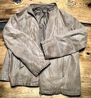 Full view of the Danier leather jacket showing front side with sleeves and zipper pockets, laid flat on a wooden surface.
