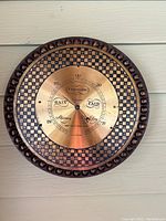 Front view of vintage circular barometer showing brass dial with rain and fair indicators and detailed decorative bezel.
