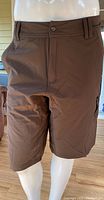 Front view of brown Lululemon men's shorts displaying button closure and belt loops, fitting size 34.