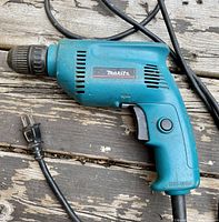 Side profile view of Makita 6410 drill showing shape, cord and trigger.