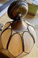 Photo of the light fixture showing the full stained glass shade and metal ceiling mount.