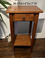 Front view of wooden accent table showing one drawer with metal ring pull and lower shelf. Dimensions 29.5 inches high, 14 inches deep, 17 inches wide are visible.