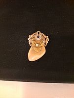 Front view of vintage 10K yellow gold Elks Lodge social club pendant with elk design on black background.