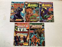 Five Marvel vintage comic books laid out flat showing covers: Dead of Night No. 02909 (1975), two Werewolf by Night No. 02155 (1974), Vault of Evil No. 02183 (1975), and Daredevil No. 02459 (1974). Covers have colorful artwork and visible age-related wear.