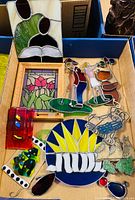 Image showing box with various fused and stained glass items including framed floral panel, colorful glass figurines and decorative pieces with scratches.