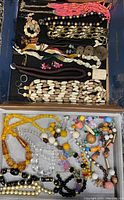 Full overview of assorted vintage and modern necklaces with various beads and materials in a box.