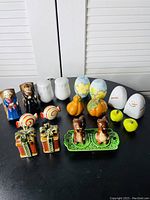 Photo showing entire set of diverse ceramic salt and pepper shakers including figurines, pumpkins, apples, and gifts
