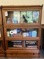 Front view of three-tier oak bookcase loaded with contents