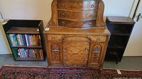 Two vintage bookshelves, one black with books, one smaller wooden with scratches, shown alongside a wooden dresser (not included).