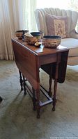 Side view of solid wood drop leaf table showing wood grain and spindle legs