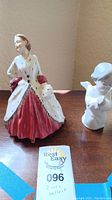 Photo showing both Royal Doulton woman figurine and Lladro cherub bust side by side on table.