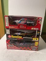 Stacked NASCAR die cast cars in original packaging featuring Valvoline Racing graphics.