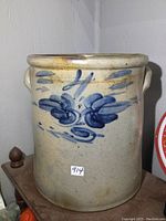 Front view showing light gray glaze and hand-painted blue floral motif