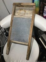 Front view of antique wooden Baby Globe washboard with metal scrubbing panel, logo and manufacturing info visible.