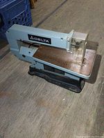 Side view of Delta 13 inch scroll saw showing saw blade, work table, and safety guard