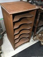 Angled side view of the record cabinet showing open shelves and wood finish