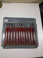 Full view of the 12 wood carving chisels in blue fabric case pouch labeled Pyramid.